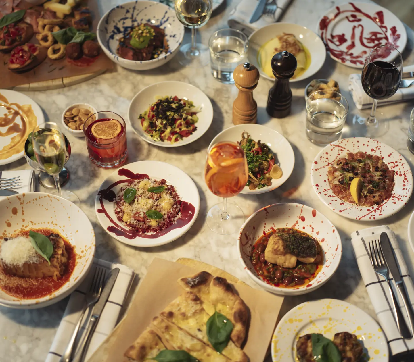 Dinner with four plates and wine glasses photographed from above