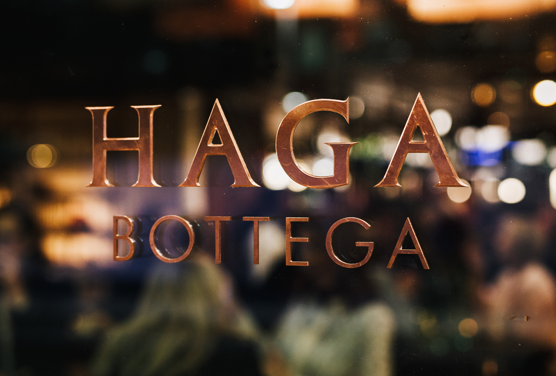 Restaurant environment with "Haga Bottega" logo in the foreground